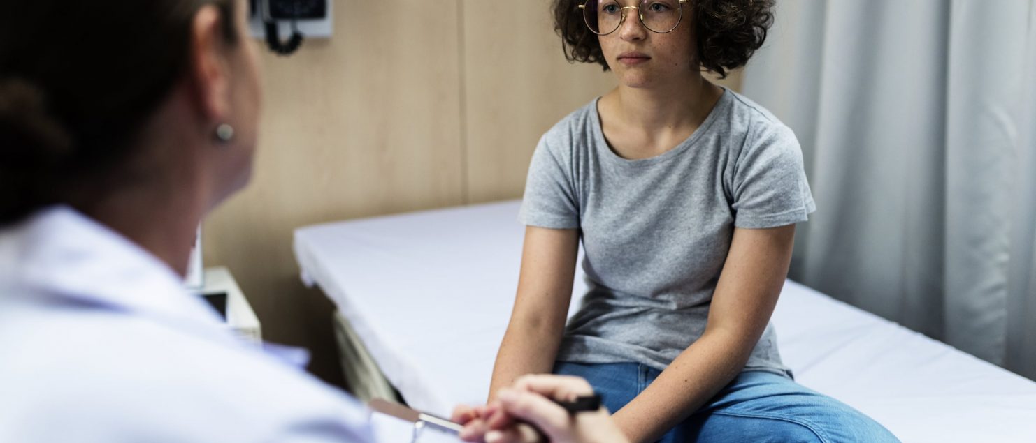 A cuban woman receiving a consultation at a hospital bedside