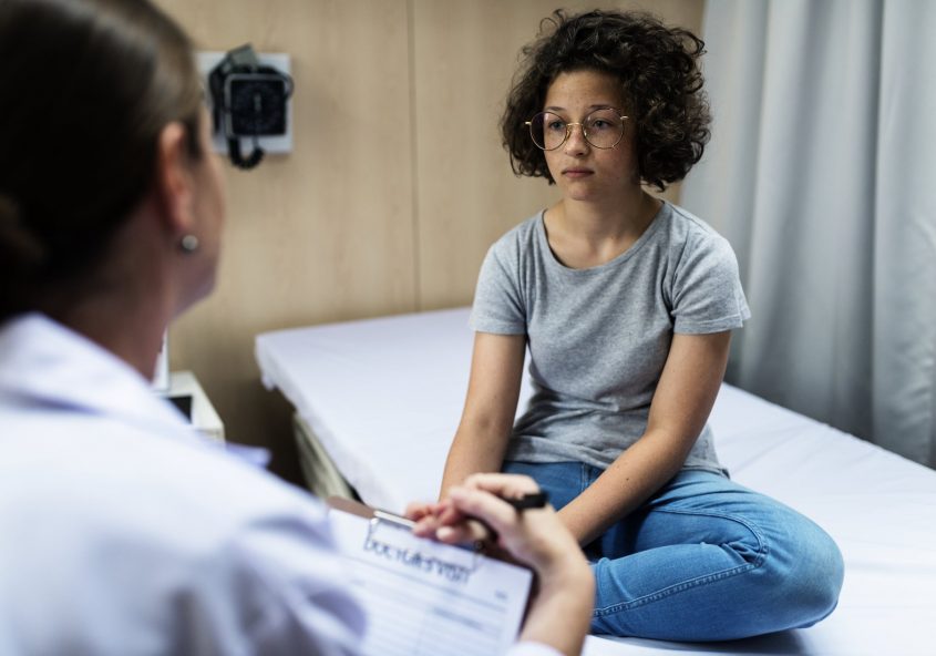 A cuban woman receiving a consultation at a hospital bedside